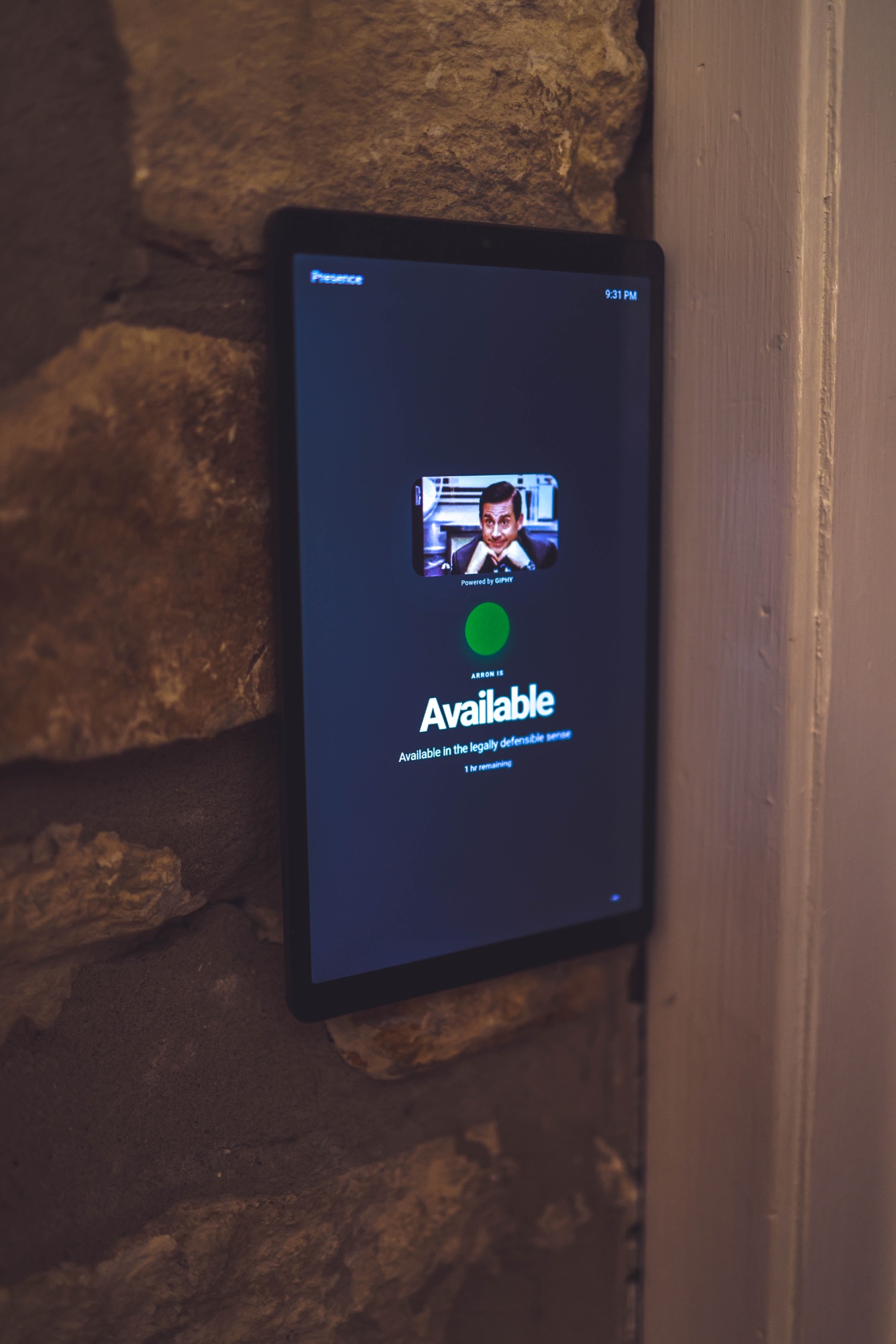 A real tablet displaying Presence beside an office door